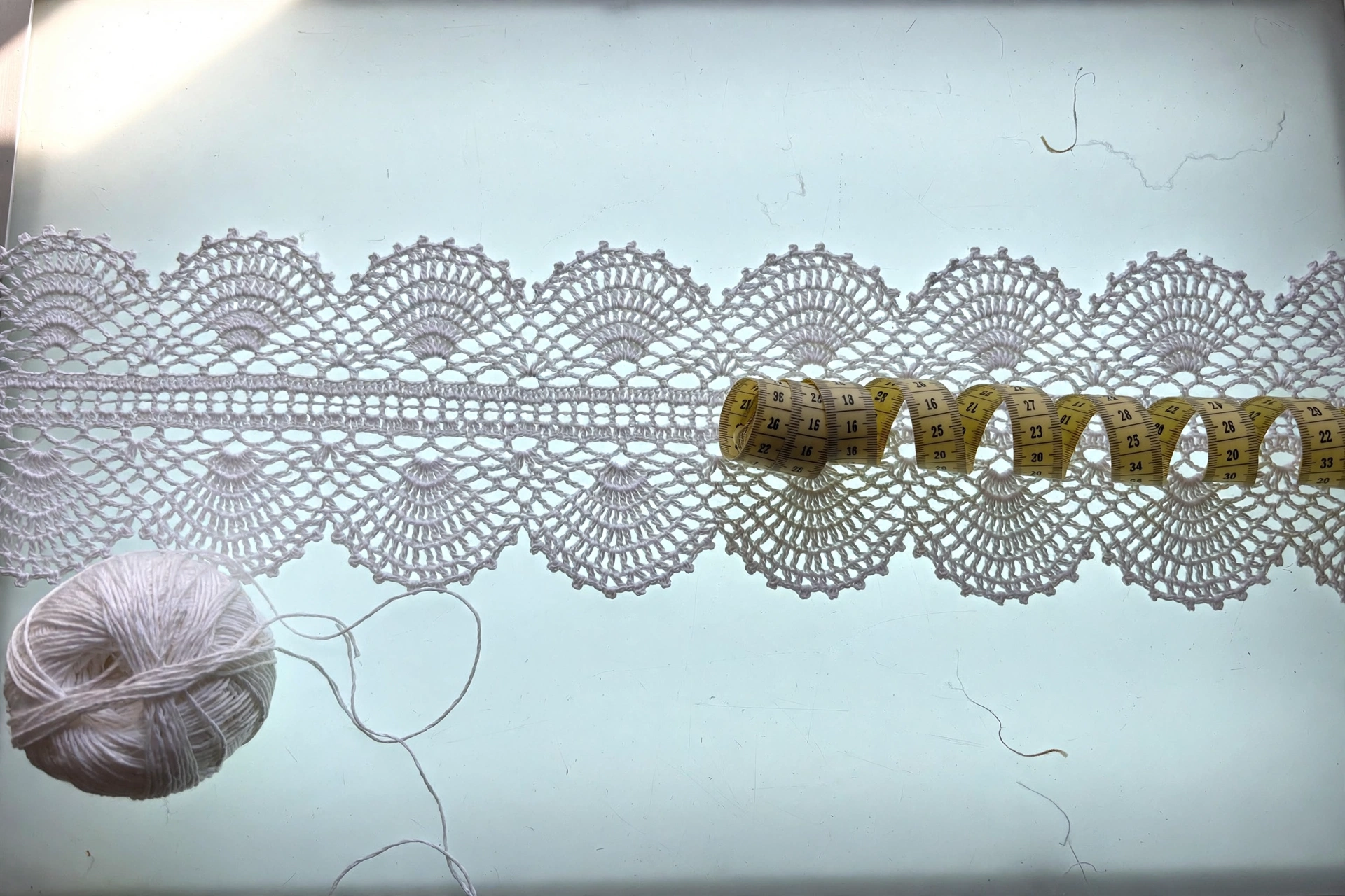 A finished length of scalloped tape from the tape lace crochet pattern being measured