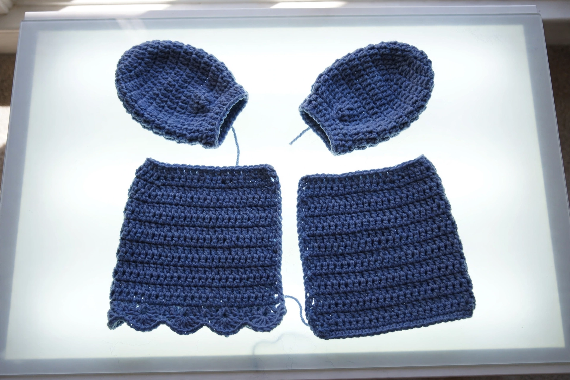 Two small sleeves worked for the baby peacoat crochet pattern beside the body panels