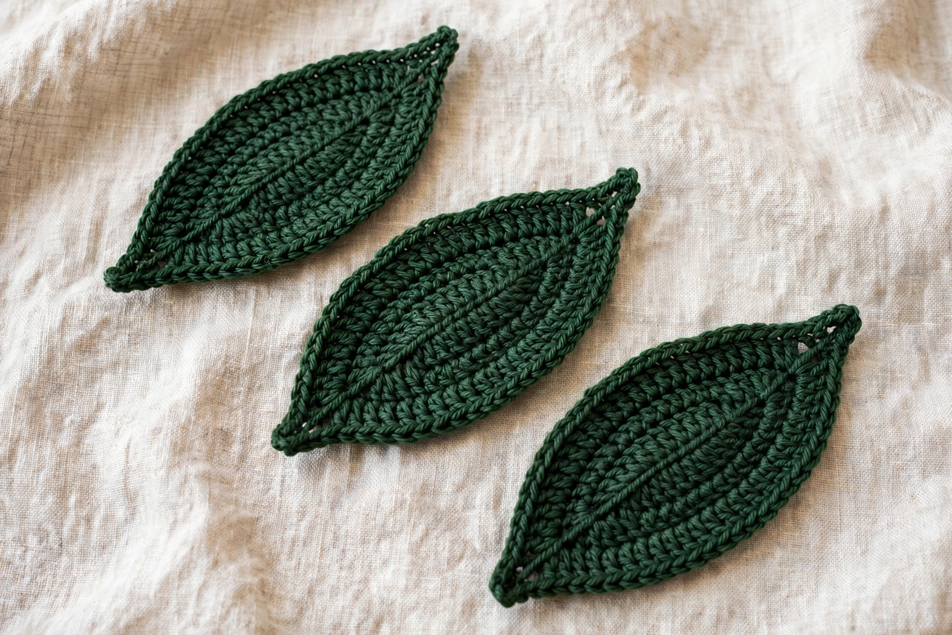 Three green crochet leaves with neat edges made for the poinsettia crochet flower pattern